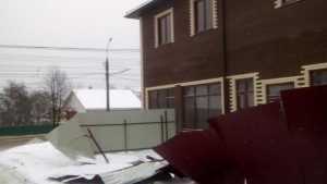 В Брянске глыба снега рухнула с крыши и завалила на тротуар забор