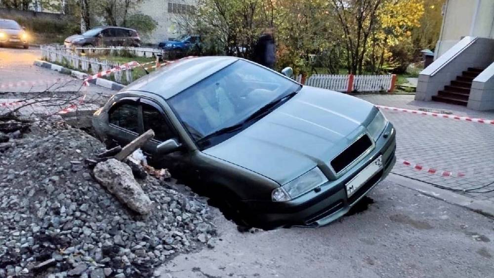 В Брянске на улице Рославльской автомобиль провалился в огромную яму возле двора дома
